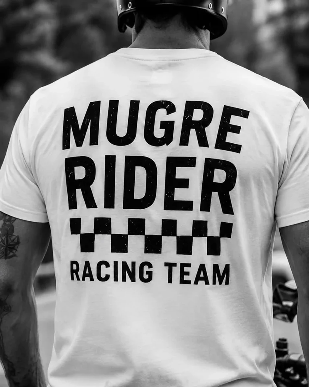 Rider con la camiseta RIDER de espaldas, sobre su moto
